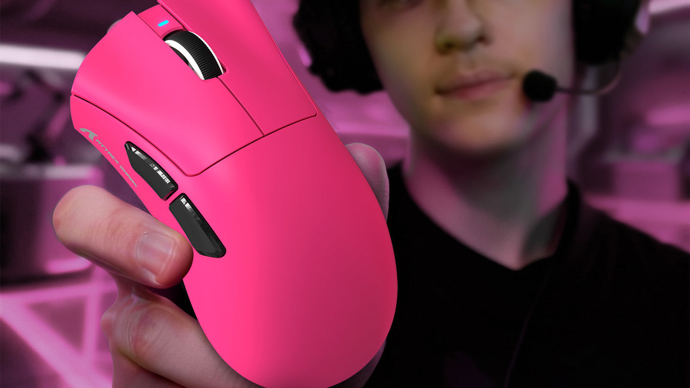 Esports gamer holding a bright pink wireless gaming mouse, showcasing its ergonomic design and side buttons.